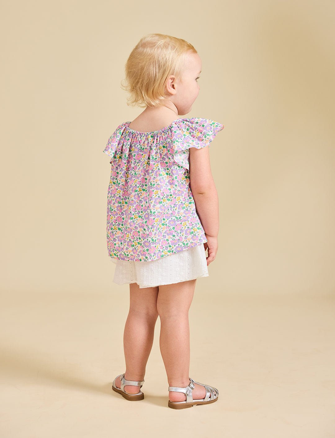 A girl with a beige background modelling a flowery top