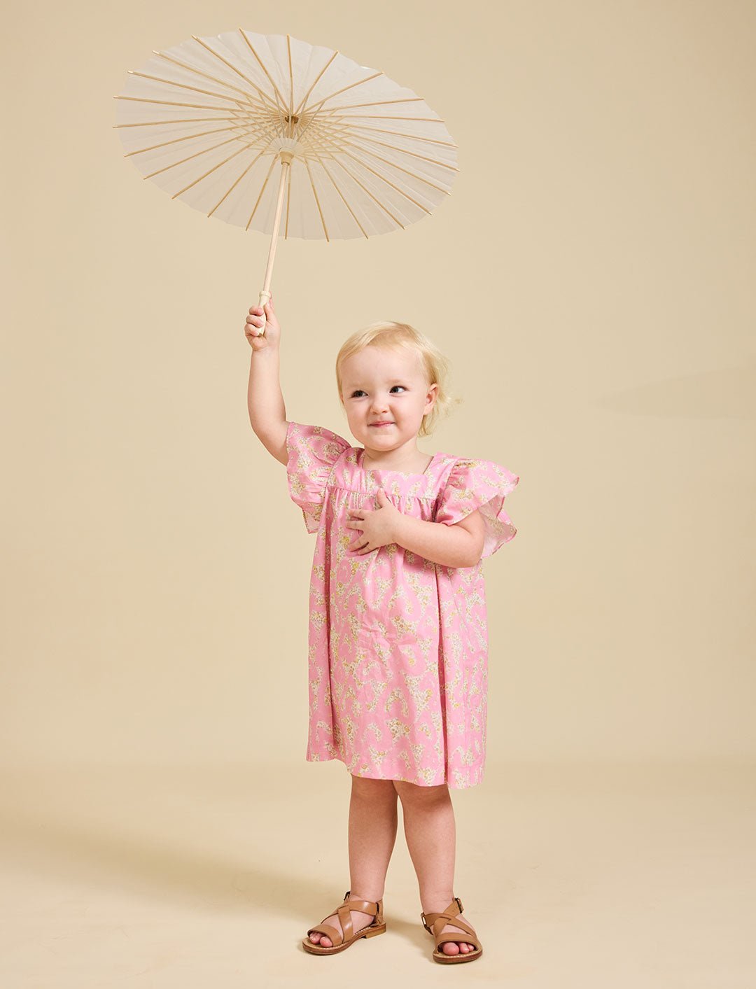 Girl holding an umbrella wearing the Margaux pink dress