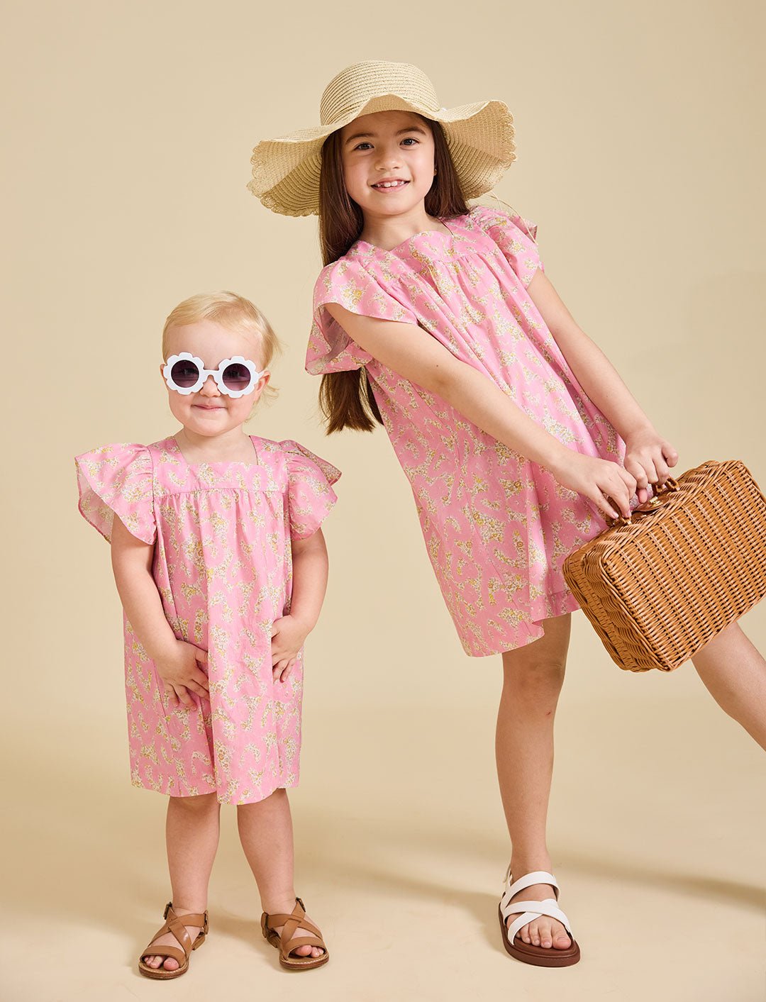 Girls wearing the liberty print Margaux dress in sunglasses and a straw hat
