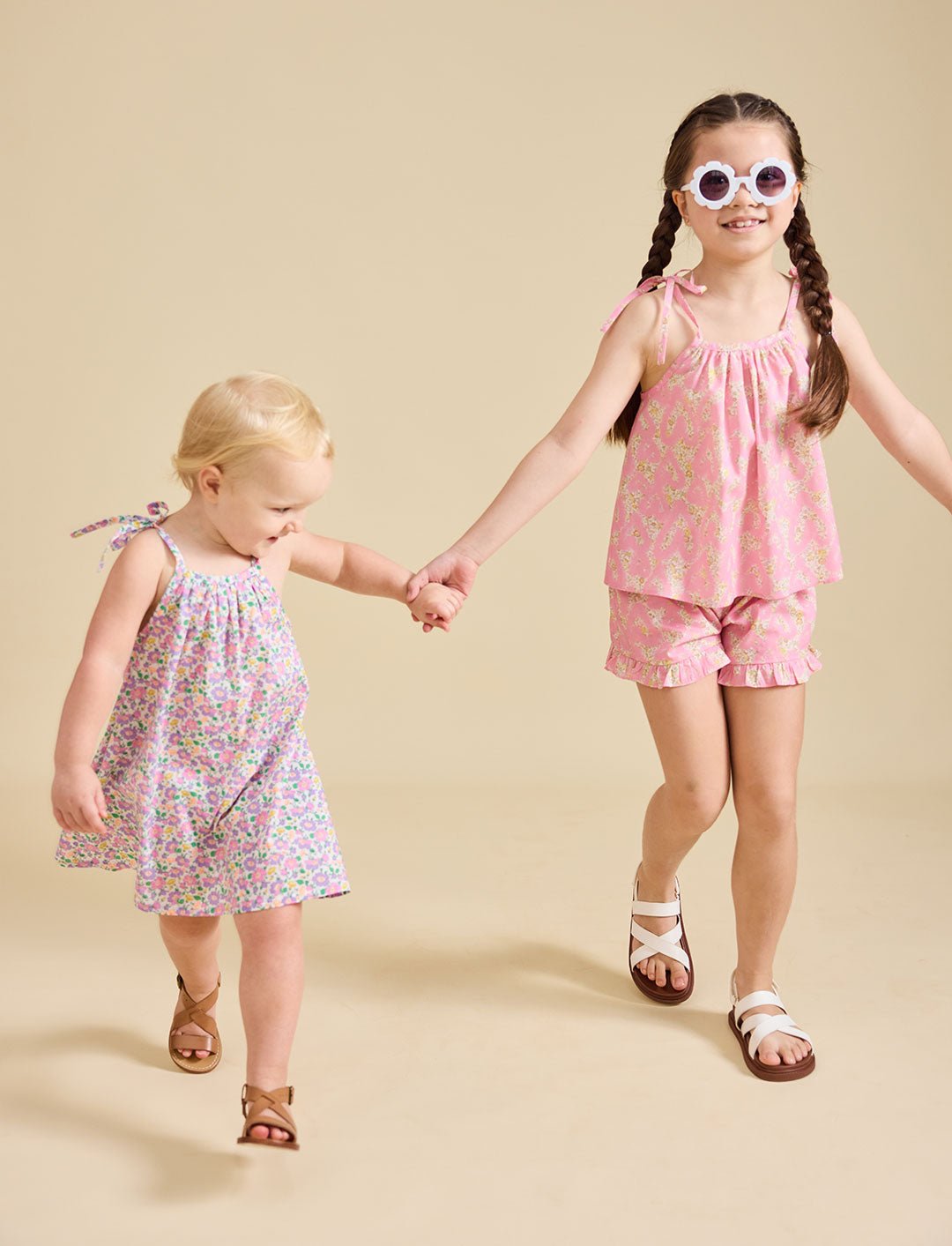 Two girls modelling the Fleur dress and Rosalie set in pink - liberty fabric