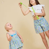 Two girls blowing bubbles wearing the Delilah liberty print range - ce-jour la