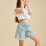 Girl modelling the delilah liberty print shorts with a beige background - ce-jour la