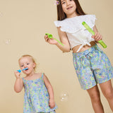 Two girls blowing bubbles wearing the Delilah liberty print range - ce-jour la