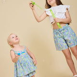 Two girls blowing bubbles wearing the Delilah liberty print range - ce-jour la