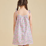 Back view of girl wearing the fleur dress with beige background 