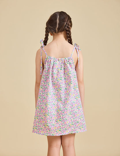Back view of girl wearing the fleur dress with beige background 