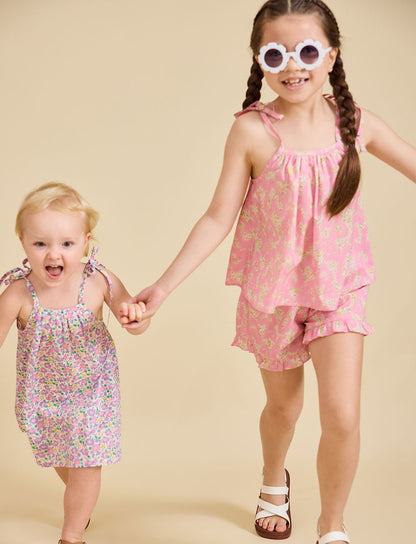 Young girl running towards the camera wearing the ce-jour la fleur dress
