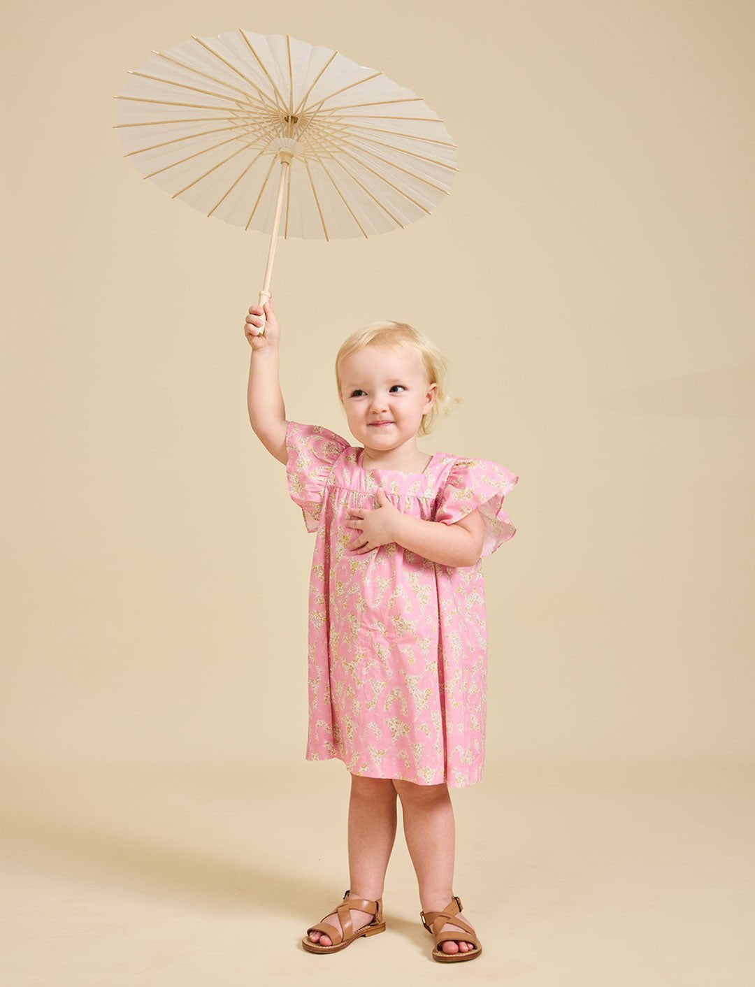 Girl holding an umbrella wearing the Margaux pink dress