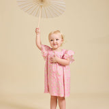 Girl holding an umbrella wearing the Margaux pink dress