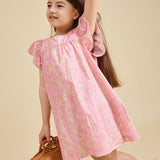 Girl on a beige background wearing the Margaux dress in pink